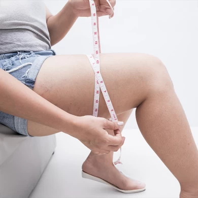 A woman measuring her thighs and showing how to get slim legs without going to the gym.